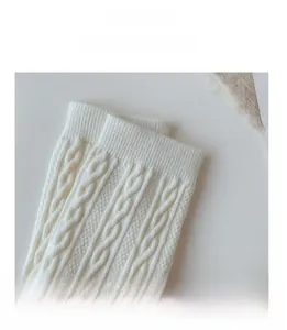 Close-up of high-elasticity ribbed cuff on white cable knit wool blend socks