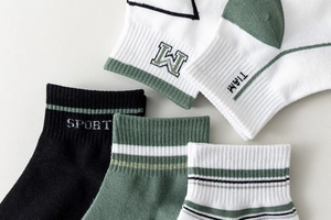 Detailed close-up of ribbed cuffs on breathable cotton socks with athletic letter patterns