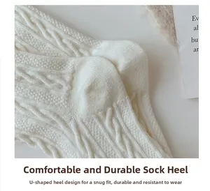 Detail of white wool socks showing the durable U-shaped heel and cable knit texture