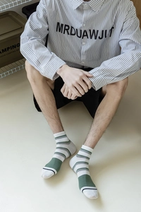 Detailed view of American retro striped cotton crew socks with green ribbed cuffs