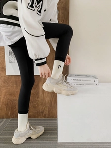 Detail of white cotton socks with black letter P embroidery and chunky grey sneakers