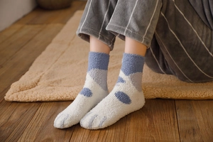 Detail of coral fleece cat paw socks showing soft fuzzy texture and cute paw print design