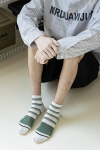 Detail of men's cotton crew socks with vintage green, beige and black horizontal stripes
