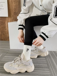 Detail shot of white athletic socks with letter embroidery and striped cuffs for women