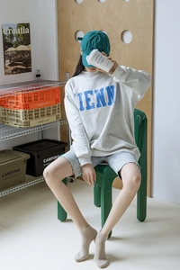 Détail d'un sweat-shirt gris en coton oversize avec un imprimé de lettres IENNA bleues