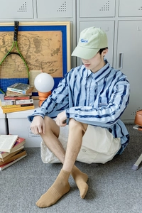 Detail of blue striped shirt paired with white cargo shorts and stylish brown socks