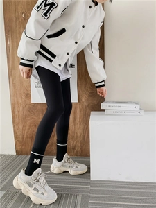 Close-up of black embroidered striped socks worn with sporty sneakers and a casual jacket