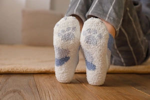 Detail of warm blue cat paw print on soft white coral fleece thermal winter socks