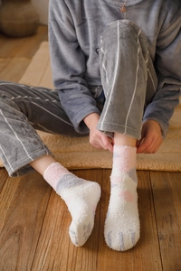Close-up of warm coral fleece socks with cat paw pattern and soft plush texture