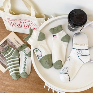 Flat lay of women's cotton ankle socks with green stripes, bear, and strawberry patterns