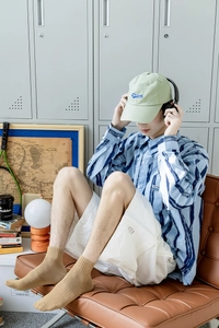 Close-up of camel knit socks styled with blue tie-dye shirt and casual white shorts