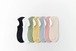 Close-up of seven pairs of breathable mesh boat socks in various pastel solid colors
