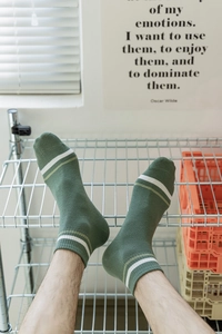 Close-up of dark green breathable cotton ankle socks with white and light green stripes