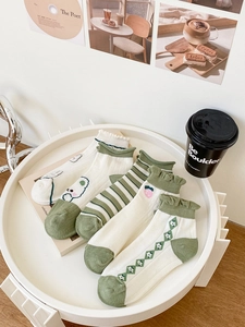 Detail of five cotton socks featuring bear embroidery and green strawberry patterns
