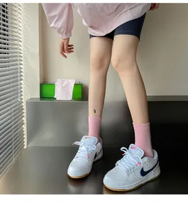 Close-up of pink cotton mid-calf socks paired with white sneakers in a stylish soft girl look
