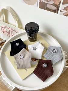 Détail de cinq paires de socquettes en coton avec broderie sourire aux couleurs neutres