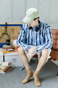 Close-up of men's khaki ribbed cotton crew socks paired with casual shorts and sneakers