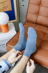 Close-up of greyish-blue cotton socks with ribbed cuffs and elastic mid-foot support