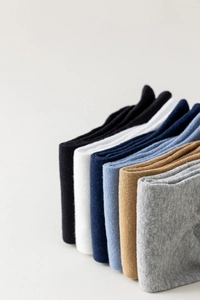 Close-up of assorted cotton socks in black, white, navy, and gray with ribbed texture