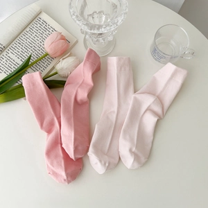 Soft pink cotton mid-calf socks for women in a minimalist home lifestyle setting