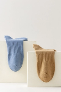Detailed knit texture of blue and khaki cotton crew socks on geometric stands
