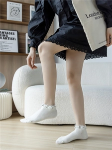 Detailansicht weißer Baumwollsocken mit elegantem Spitzenrand und Perlenbesatz