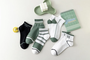 Detailed flat lay of five pairs of men's breathable cotton ankle socks in green and black