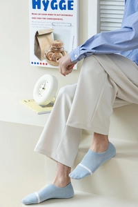 Detail of light blue invisible socks for men featuring minimalist white stripe decoration