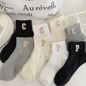 Detailed view of ribbed knit socks featuring premium letter P embroidery in neutral colors