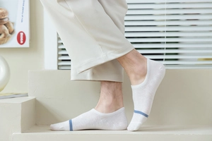 Close-up of white cotton no-show socks featuring blue stripes and ribbed cuffs for men