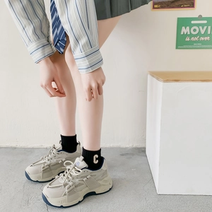 Detail of chunky retro sneakers in beige leather and mesh with navy blue accents