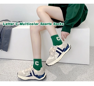 Close-up of green cotton sports socks featuring a vintage white letter C jacquard detail