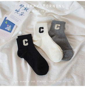 Detail view of cotton rib-knit socks in black, beige, and grey with letter C jacquard