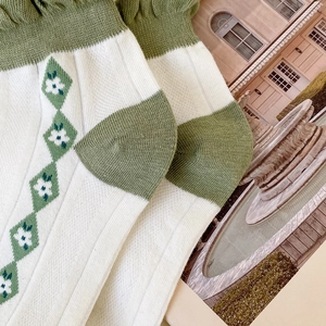Detail of green argyle pattern and ruffled cuffs on cotton low cut socks for women