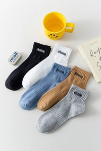 Détail de cinq paires de chaussettes en coton avec broderie FREEDOM et bords côtelés