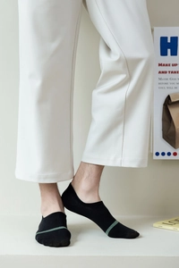 Close-up of black cotton invisible sock for men featuring a green toe stripe detail