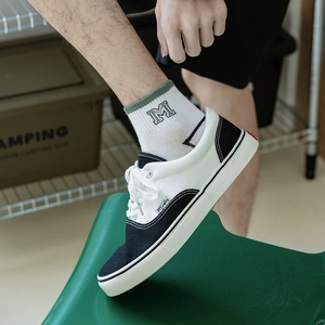 Men's breathable low-cut canvas shoes with white athletic socks in a camping setting