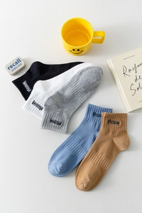 Détail de chaussettes en coton avec étiquettes Freedom en noir blanc gris bleu et kaki