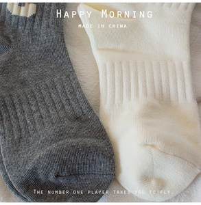Close-up of ribbed knit texture on grey and off-white cotton short socks for women