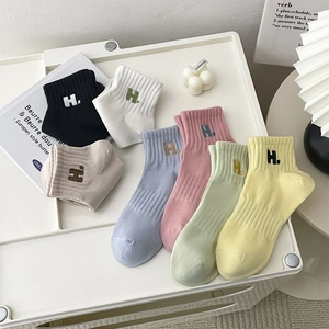 Close-up of cotton blend ankle socks featuring ribbed texture and H letter embroidery