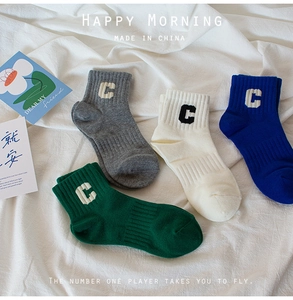 Detail of ribbed cotton crew socks in multiple colors with C letter embroidery