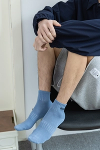 Détail d'une chaussette bleu clair pour homme avec broderie FREEDOM noire sur le bord