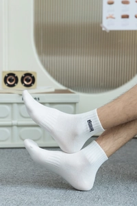 Détail de chaussettes de sport en coton blanc avec logo Freedom noir et bords côtelés