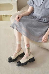 Detail of sheer cream mid-calf socks with tulip embroidery and Mary Jane platform shoes