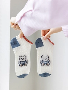 Detail view of cotton ankle socks featuring blue polka dots and cute bear pattern