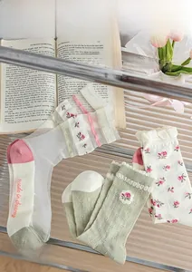 Detail of sheer summer socks with floral embroidery and delicate ruffled mesh edges