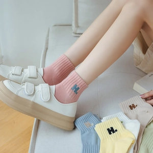Close-up of knit cotton socks with H letter embroidery in various pastel colors