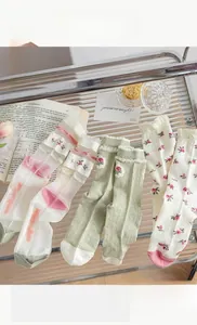 Detail of floral mid-calf socks with ruffled edges and delicate rose patterns
