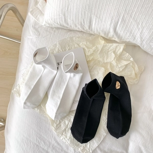 Black and white cotton ankle socks with cute brown bear embroidery in a lifestyle setting