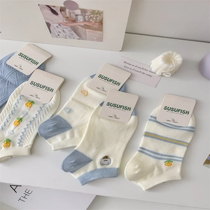 Flat lay of breathable cotton boat socks with cute animal embroidery and blue patterns